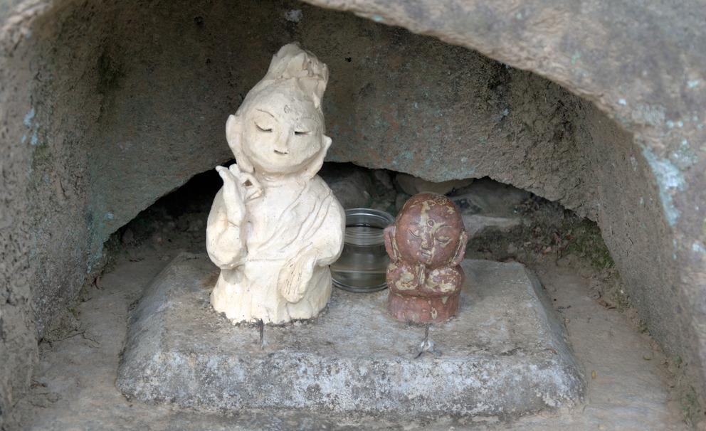 Un mini-Bouddha dans une niche de pierre